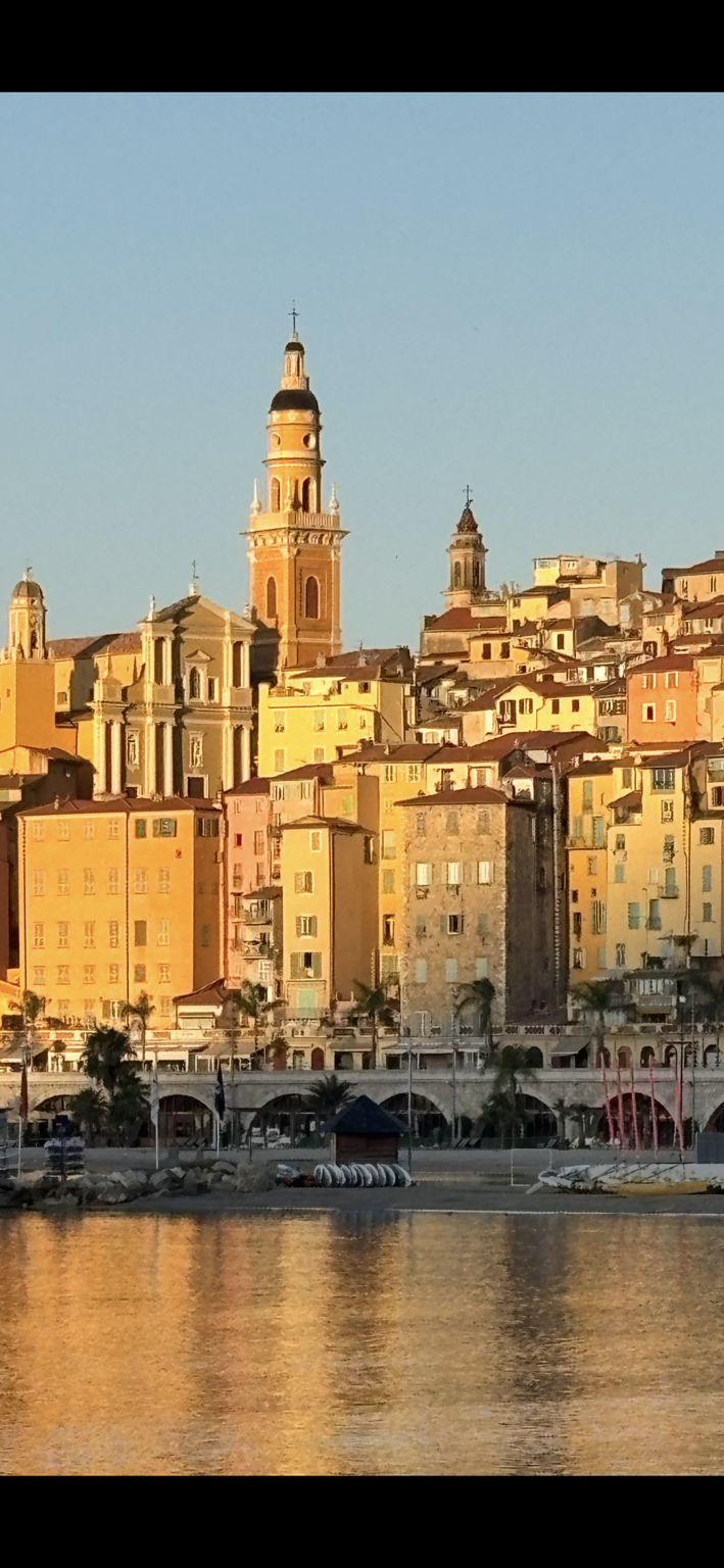 Menton’s colourful old town and bell tower overlooking the waterfront at sunset